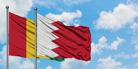 Guinea and Bahrain flag waving in the wind against white cloudy blue sky together. Diplomacy concept, international relations.
