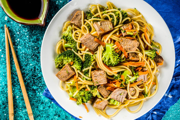 Asia food recipe. Chinese dish Beef Lo Mein Noodles with Carrots and Broccoli, top view copy space