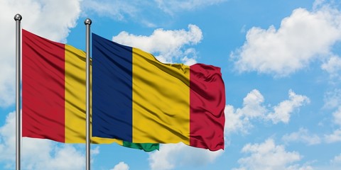 Guinea and Chad flag waving in the wind against white cloudy blue sky together. Diplomacy concept, international relations.