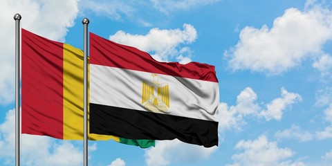 Guinea and Egypt flag waving in the wind against white cloudy blue sky together. Diplomacy concept, international relations.