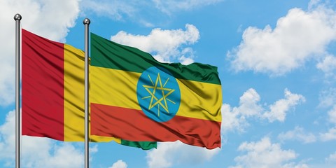 Guinea and Ethiopia flag waving in the wind against white cloudy blue sky together. Diplomacy concept, international relations.