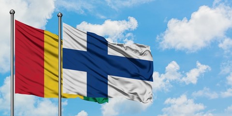 Guinea and Finland flag waving in the wind against white cloudy blue sky together. Diplomacy concept, international relations.