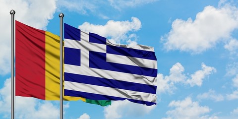 Guinea and Greece flag waving in the wind against white cloudy blue sky together. Diplomacy concept, international relations.