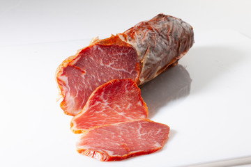 embutido iberico, lomo de cerdo cortado sobre fondo blanco.  Iberian sausage, pork loin cut on...