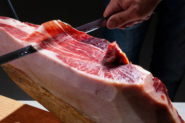  Serrano ham slice on black background. Corte de jamón serrano sobre fondo negro.