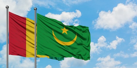 Guinea and Mauritania flag waving in the wind against white cloudy blue sky together. Diplomacy concept, international relations.