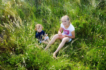 two pretty sisters playing together in tall grass