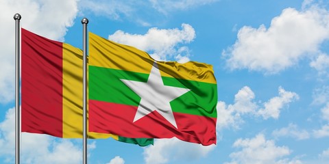 Guinea and Myanmar flag waving in the wind against white cloudy blue sky together. Diplomacy concept, international relations.