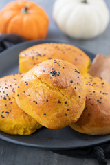 pumpkin buns on dark dish on ceramic background
