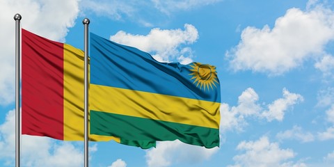 Guinea and Rwanda flag waving in the wind against white cloudy blue sky together. Diplomacy concept, international relations.