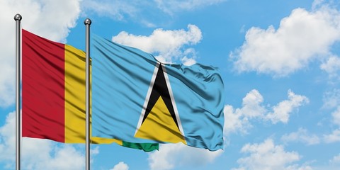 Guinea and Saint Lucia flag waving in the wind against white cloudy blue sky together. Diplomacy concept, international relations.