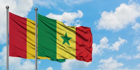 Guinea and Senegal flag waving in the wind against white cloudy blue sky together. Diplomacy concept, international relations.