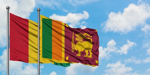 Guinea and Sri Lanka flag waving in the wind against white cloudy blue sky together. Diplomacy concept, international relations.