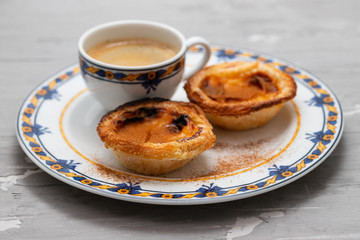 typical portuguese egg tart pastel de nata with cup of coffee on ceramic background