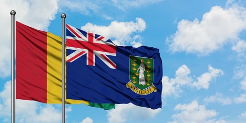 Guinea and British Virgin Islands flag waving in the wind against white cloudy blue sky together. Diplomacy concept, international relations.