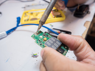 Engineer Men are analyzing the circuit boards to find the cause of the damage. Perform repair by soldering to replace the broken equipment.
