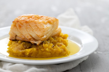 cod fish with sweet potato and olive oil on white dish