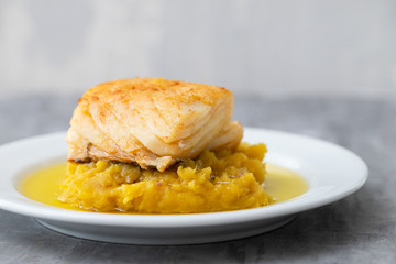 cod fish with sweet potato and olive oil on white dish