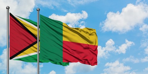 Guyana and Benin flag waving in the wind against white cloudy blue sky together. Diplomacy concept, international relations.