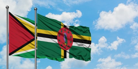 Guyana and Dominica flag waving in the wind against white cloudy blue sky together. Diplomacy concept, international relations.