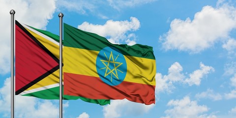 Guyana and Ethiopia flag waving in the wind against white cloudy blue sky together. Diplomacy concept, international relations.