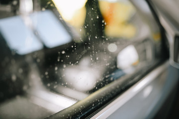 Dirty gray car at the self-service car wash