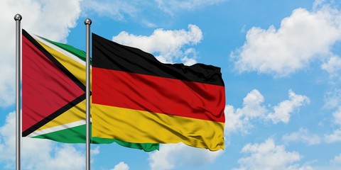 Guyana and Germany flag waving in the wind against white cloudy blue sky together. Diplomacy concept, international relations.