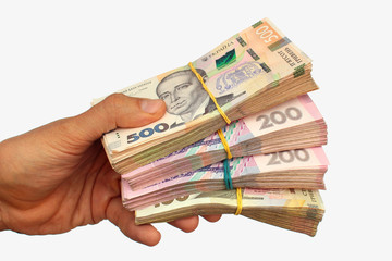 Hand with hryvnia banknotes, the money of Ukraine. Isolated against white background.
