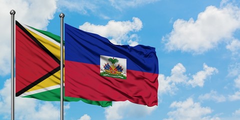 Guyana and Haiti flag waving in the wind against white cloudy blue sky together. Diplomacy concept, international relations.