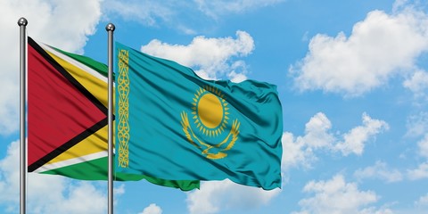 Guyana and Kazakhstan flag waving in the wind against white cloudy blue sky together. Diplomacy concept, international relations.