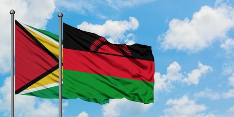 Guyana and Malawi flag waving in the wind against white cloudy blue sky together. Diplomacy concept, international relations.