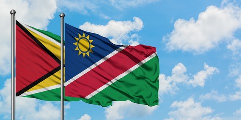 Guyana and Namibia flag waving in the wind against white cloudy blue sky together. Diplomacy concept, international relations.