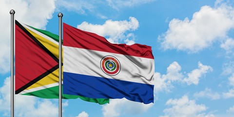 Guyana and Paraguay flag waving in the wind against white cloudy blue sky together. Diplomacy concept, international relations.