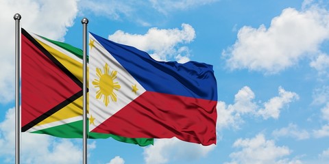 Guyana and Philippines flag waving in the wind against white cloudy blue sky together. Diplomacy concept, international relations.