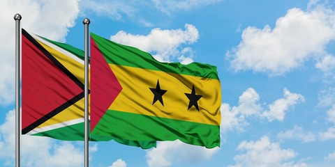 Guyana and Sao Tome And Principe flag waving in the wind against white cloudy blue sky together. Diplomacy concept, international relations.