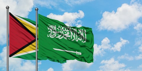 Guyana and Saudi Arabia flag waving in the wind against white cloudy blue sky together. Diplomacy concept, international relations.