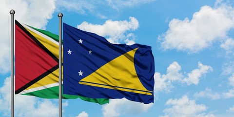 Guyana and Tokelau flag waving in the wind against white cloudy blue sky together. Diplomacy concept, international relations.