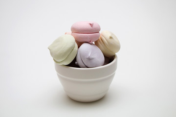 Sweet tasty marshmallows in a plate on a white background.