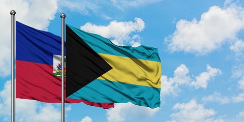 Haiti and Bahamas flag waving in the wind against white cloudy blue sky together. Diplomacy concept, international relations.