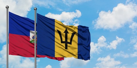 Haiti and Barbados flag waving in the wind against white cloudy blue sky together. Diplomacy concept, international relations.
