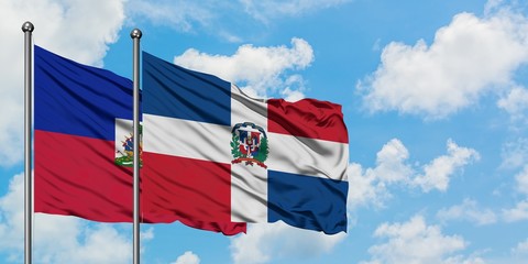 Haiti and Dominican Republic flag waving in the wind against white cloudy blue sky together. Diplomacy concept, international relations.