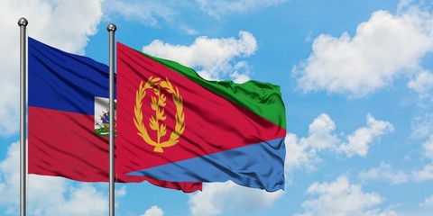 Haiti and Eritrea flag waving in the wind against white cloudy blue sky together. Diplomacy concept, international relations.