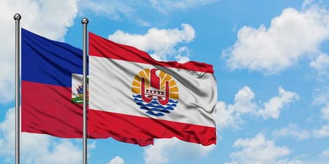 Haiti and French Polynesia flag waving in the wind against white cloudy blue sky together. Diplomacy concept, international relations.