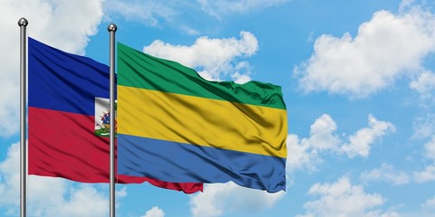 Haiti and Gabon flag waving in the wind against white cloudy blue sky together. Diplomacy concept,...