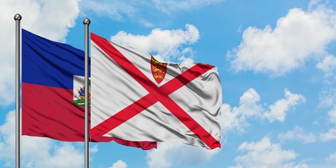 Haiti and Jersey flag waving in the wind against white cloudy blue sky together. Diplomacy concept, international relations.