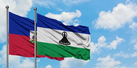 Haiti and Lesotho flag waving in the wind against white cloudy blue sky together. Diplomacy concept, international relations.