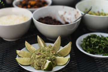 Mexican Guacamole dip with lime slices and doritos or nachos crisps