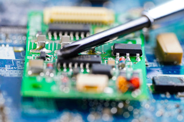 E-waste, repairing inside of hard disk by soldering iron. Integrated Circuit. the concept of data,...