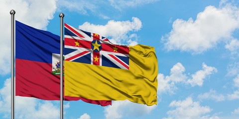Haiti and Niue flag waving in the wind against white cloudy blue sky together. Diplomacy concept, international relations.
