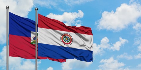 Fototapeta na wymiar Haiti and Paraguay flag waving in the wind against white cloudy blue sky together. Diplomacy concept, international relations.